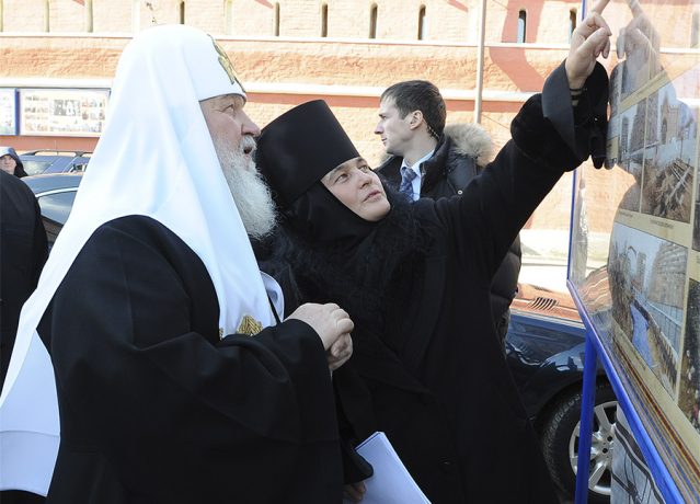 Abbess Feofaniya shows to the Primate of the Russian Church photographs of the work performed stages